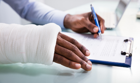 Person filling out paperwork with a broken arm.