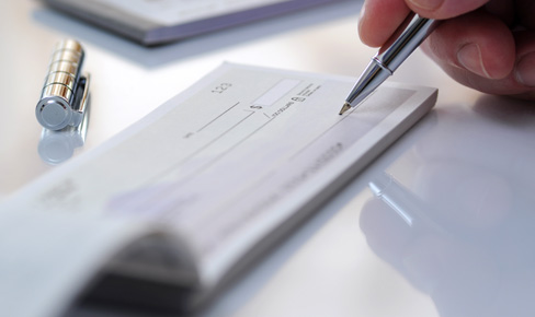 Close-up photo of a person writing a check